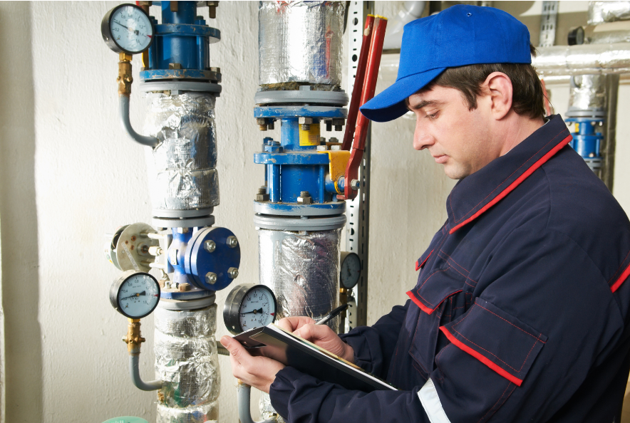man checking boiler controls and guages