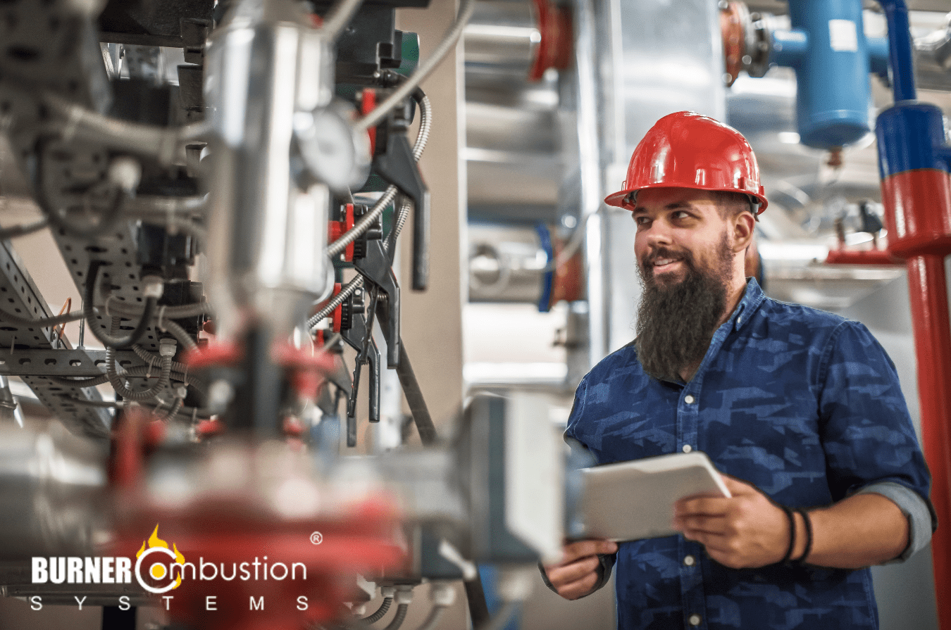 man with red hard hat looking at boiler system