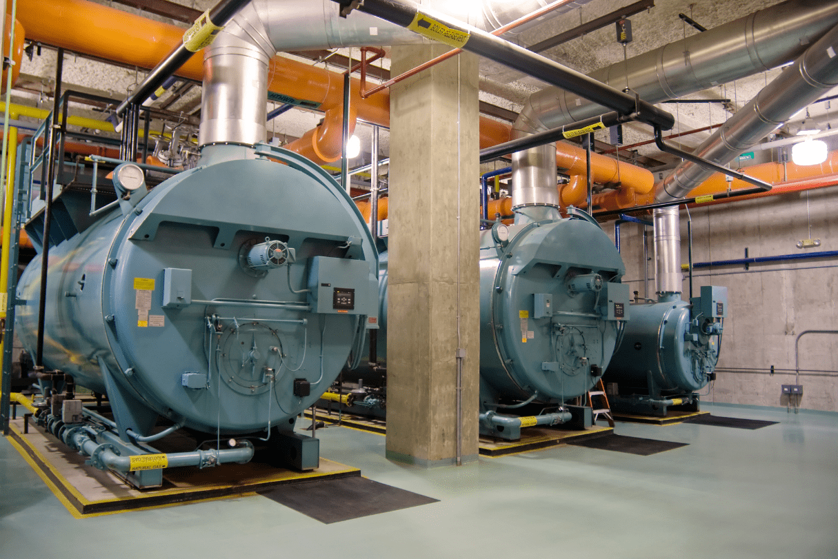 two gray boilers, orange pipes